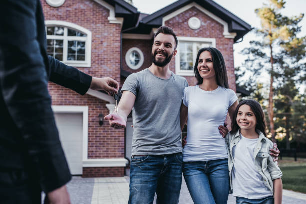 Happy family is taking keys from their new house from broker and smiling.